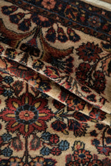 A vintage Borchalou rug folded to show the plush texture and navy and terracotta floral details.