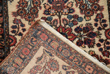 A vintage Borchalou rug's corner folded back to show its hand-knotted foundation and selvage.