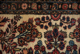 Close-up of the vintage Borchalou rug's pile showing bouquets and budded stems in navy and terracotta.
