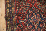 Vintage Borchalou runner corner, highlighting brick red field, blue palmette border, and side cord.