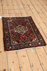 Vintage Dargezine rug corner with cherry red, dark bronze floral border and blue side selvage.