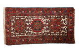 Vintage Karaja rug runner with three geometric medallions in brick red and dark navy blue on an ivory field.