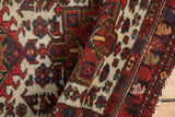Angled detail view of the even pile and polychromatic selvage on a vintage Karaja rug.