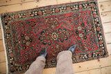 Vintage Persian rug featuring a dense field of floral sprays and a multi-layered border.