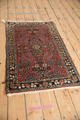 Full angled view of a vintage Dargezine rug with a brick red field and dark navy floral details.