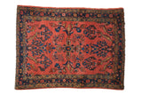 Vintage hand-knotted Lilihan rug with dark coral field, sprawling floral vines, sapphire starburst border.