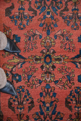 Vintage Lilihan rug close-up: coral field with sapphire blue, gold, and brown floral vines.