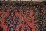Vintage Lilihan rug corner close-up, highlighting dark coral sprawling vines and starburst border.