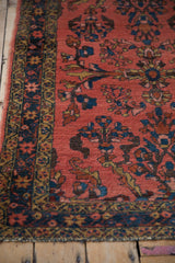 Close-up of vintage Lilihan rug with coral field, sapphire blue border, and ornate floral vines.
