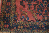 Vintage Lilihan rug corner: coral field, sapphire blue vines, gold border, original selvage.