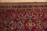 Meandering vine main border and pearl seed minor borders of a vintage raspberry red Sarouk rug.