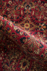 Close-up showing the even, hand-knotted pile and floral motifs of a vintage Sarouk rug.
