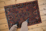 Intricate central floral vines and colorful boteh main border of a vintage Mehriban rug.