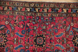 Expressive ruby red field with scrolling vines, vibrant motifs, and multi-band border on antique Lilihan rug.