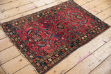Upper corner of Antique Lilihan Persian rug, vibrant raspberry field with expressive floral motifs.