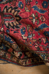 Ornate border and raspberry red field with expressive patterns on antique Lilihan rug.