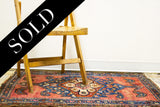 Jewel rose motif, tribal arrows, and deep indigo on the vintage Persian Hamadan rug.