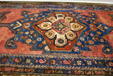 Vibrant jewel rose and tribal arrows in a deep indigo medallion of this vintage Persian rug.