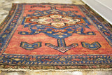 Finely knotted end of a vintage Persian Hamadan rug, deep rose field, tribal motifs.