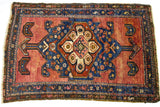 Jewel rose and tribal arrow patterns on the deep indigo medallion of this Persian rug.