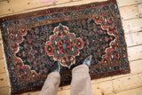 Persian Dargezine rug with scalloped medallion, Herati field, dusty red and navy hues.
