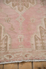 Machine bound fringe and faded pale fuchsia, coffee brown pile of a vintage Mazlaghan rug.