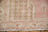 Mazlaghan rug corner, pale pink and brown distressed patterns, machine bound edge, and fringe.