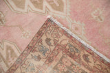 Machine-bound edge, fringe, and woven reverse of a distressed Mazlaghan rug.