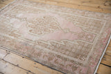 Mazlaghan vintage rug corner showing worn pink, pale brown, and ivory geometric motifs.