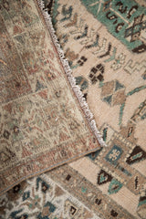 Distressed vintage Hamadan rug showing hand-knotted pile texture, subtle geometric motifs, and fringe.