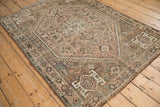 Qashqai rug machine bound side, geometric border, muted dusty mauve, and visible wear.