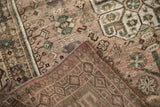 Qashqai rug folded back, revealing worn dusty mauve pile, machine bound edge, and woven foundation.