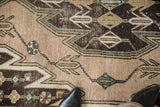Interconnected stepped vinery and geometric patterns on vintage Mazlaghan rug in beige, brown, green.