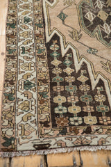 Vintage Mazlaghan rug corner detail with dark brown field, pale gold vinery, machine bound side.
