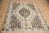 Close-up of Mazlaghan rug border with stylized motifs in camel, green, and ivory.