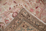 Distressed Hamadan rug corner showing worn ivory, pink floral motifs, and its hand-knotted back.