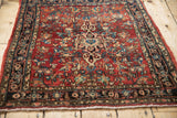 Vintage Bijar rug's navy Herati Samovar border with intricate cherry red floral field.