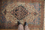 Antique Farahan Sarouk rug detail with charcoal medallion, delicate vinery, and abrashed blue spandrels.