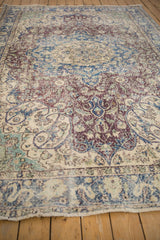 Worn floral vines and arabesques in cobalt, violet, and ivory on a distressed Sparta rug.