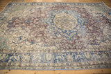 Distressed cobalt blue and ivory border with violet floral arabesques on a vintage Sparta rug.