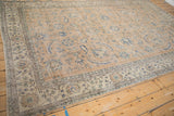 Corner of distressed Sparta carpet, showing worn camel field and blue and ivory border.