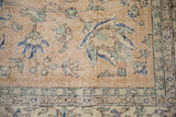 Distressed Sparta carpet detail, camel field with cobalt blue leaves, and worn pile revealing foundation.