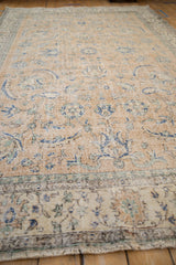 Distressed Sparta carpet detail, featuring faded camel, blue motifs, and visible foundation wear.