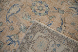 Distressed Sparta rug folded, revealing worn Herati pile, foundation, and machine-bound edge.