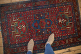 Vintage Karaja rug detail shows cherry red pinwheel blossoms and sapphire blue starburst border.