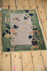 Detail of dark cobalt vase and blush floral branches on antique Nichols Art Deco rug.