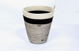 A handmade cotton rope basket with a wide black stripe and detailed cross-stitching.
