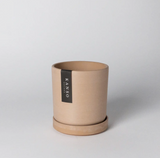 Modern cylindrical planter in a muted coral color with a matching saucer.