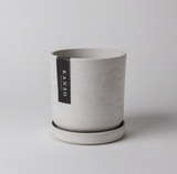 4 inch white stone recycled planter with an earthy mottled texture and matching saucer.