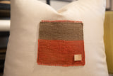 Woven brown and reddish-orange vintage Aguayo patch on pillow, with a '012' leather tag.